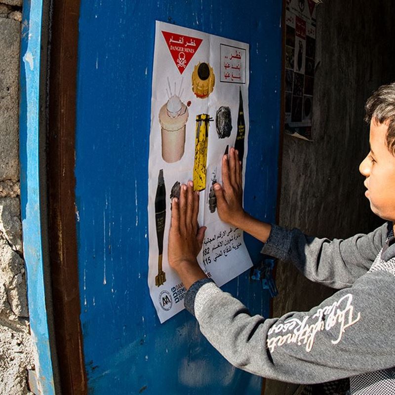 Plakater informerer børn om miner og fortæller, hvad de skal passe på i deres hverdag. 